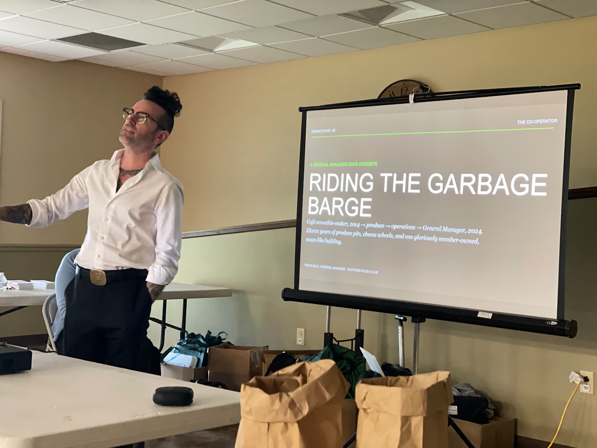 Tyler presenting a slide titled 'Riding the Garbage Barge' at a cooperative gathering
