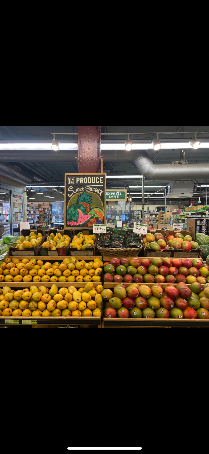 Sweet Summer produce display of yellow and red mangoes