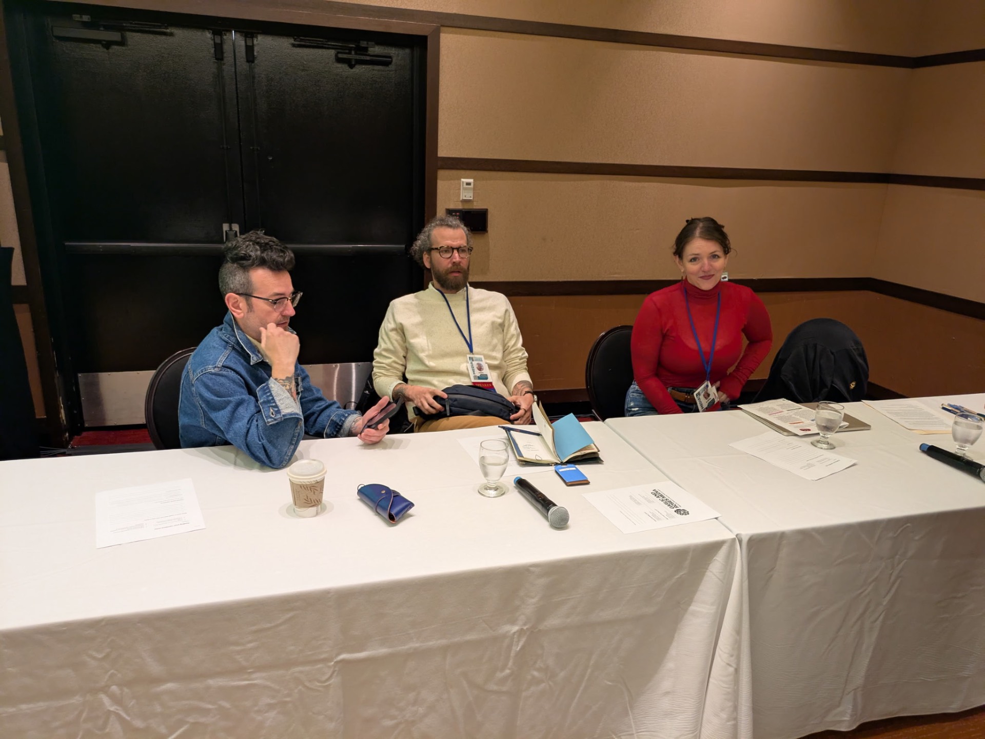 Cooperative movement speakers seated at a conference panel table